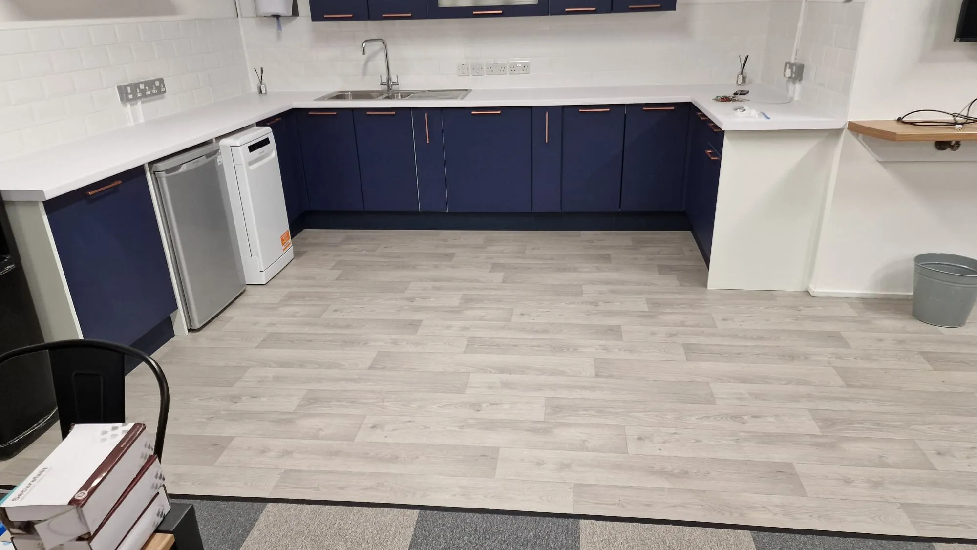 A kitchen with blue cabinets and white counters.