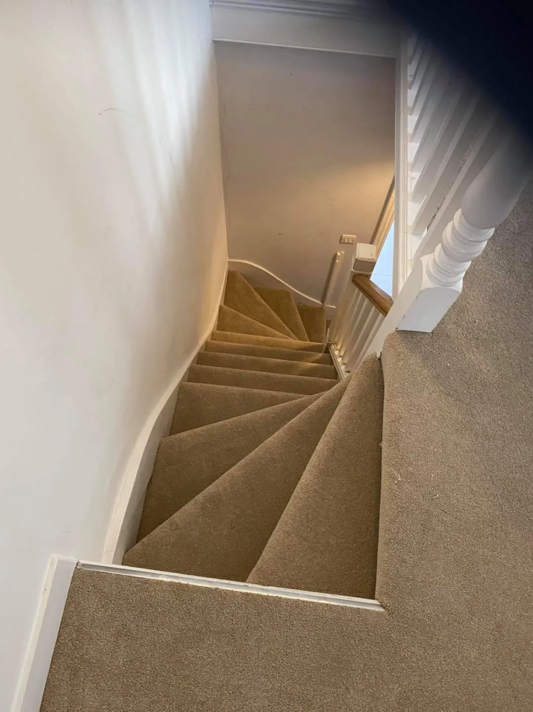 A view of a staircase from the top of the stairs.
