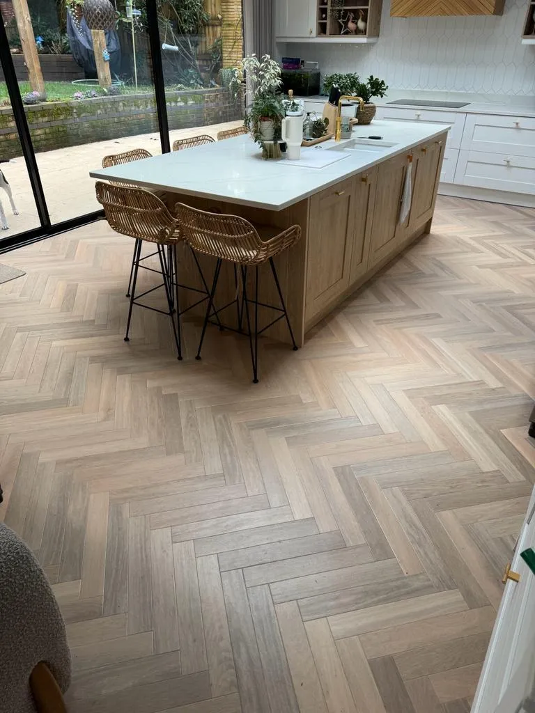 A kitchen with a large center island and wooden floors.