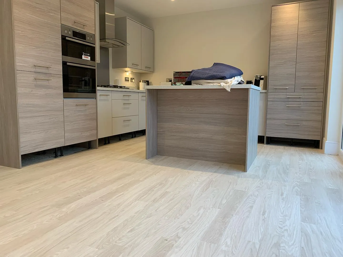 A kitchen with a counter, oven and cabinets.